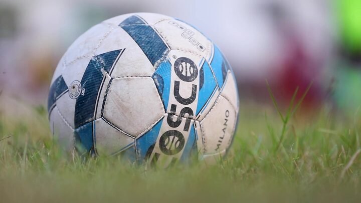 Slow-motion close-up of a football on the grass